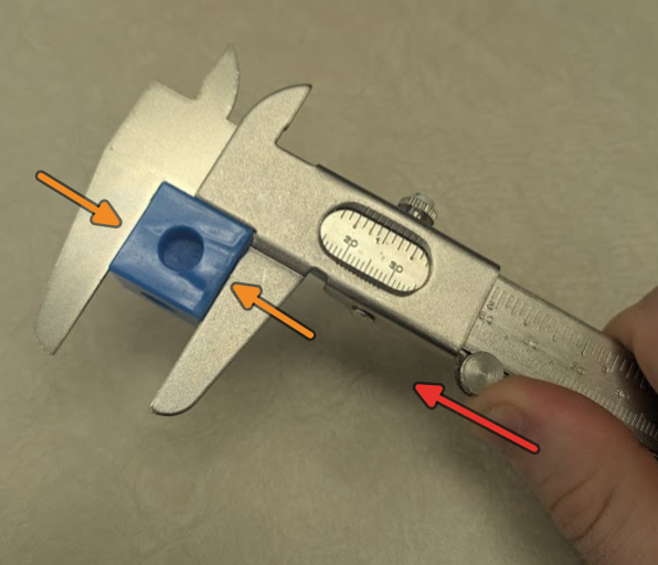 Part rests square inside of the jaws, light pressure is applied to the left with your thumb on the thumb screw