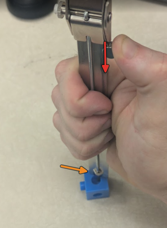 The base of the main scale should be square/flush/flat with the surface of the part you are referencing from. Light pressure is applied down using the thumb screw.